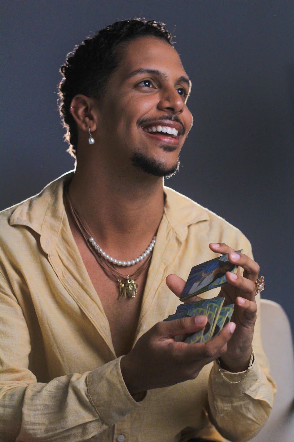Natan sorrindo com as cartas nas mãos